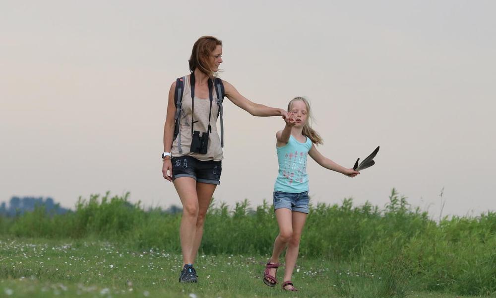 Woman and child walking with binoculars