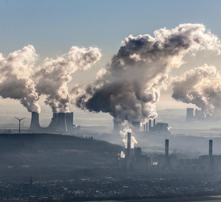 Aerial photo of coal fired power stations Neurath near Grevenbroich and Niederaussem near Bergheim in the Rhenish lignite mining area. Steam coming out of cooling towers. Windturbines near the plant.