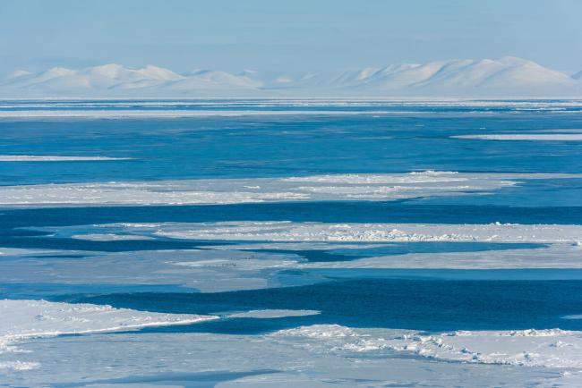 Sea ice in the Bering Strait between Little Diomede (Iŋaliq) and Nome, Alaska, with Seward Peninsula mountains on the horizon